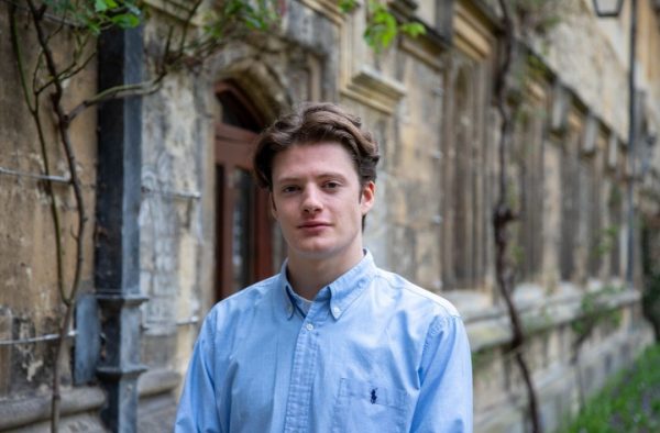 Alessandro standing in Oriel College in a light blue shirt