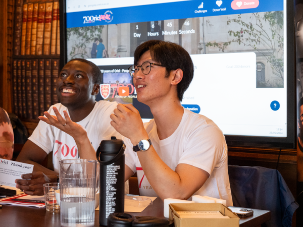 Two young men sitting at a table smiling