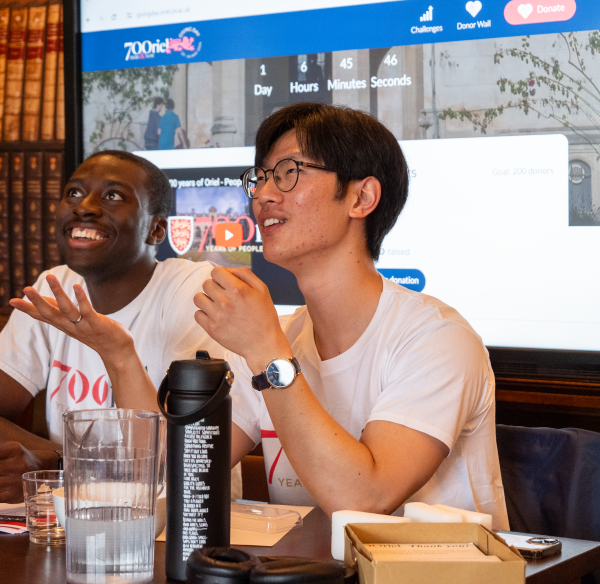 Two young men sitting at a table smiling